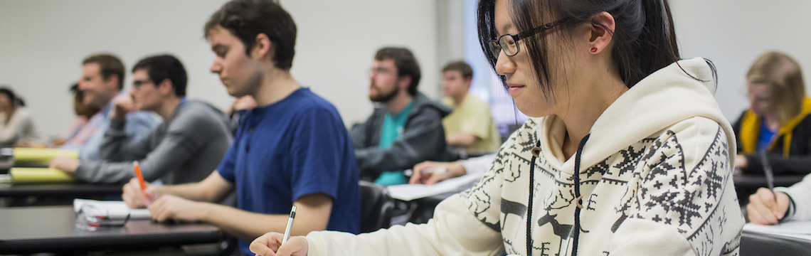 Students taking notes during a class lecture.