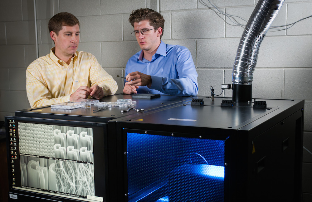 Two researchers constructing a GT logo in the lab.